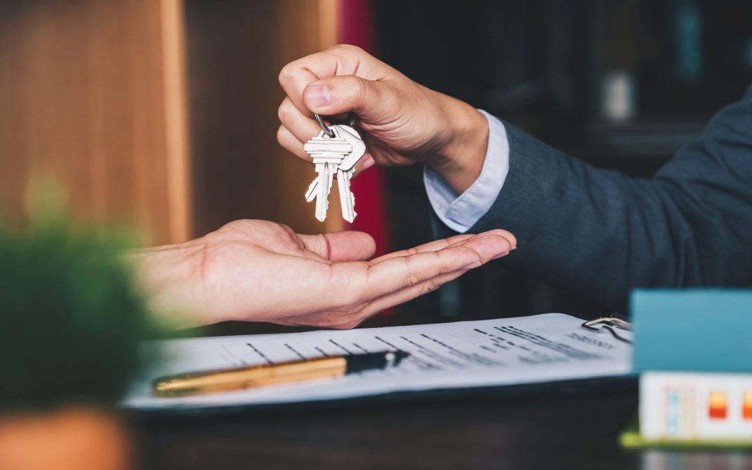 estate-agent-giving-house-keys-to-woman-and-sign-agreement-in-office-1130829500_6000x4000